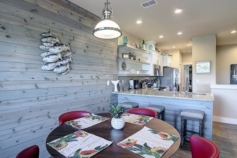 Your coastal-inspired dining area opens to a chef's kitchen, where weathered wood walls and nautical touches create a relaxing retreat.