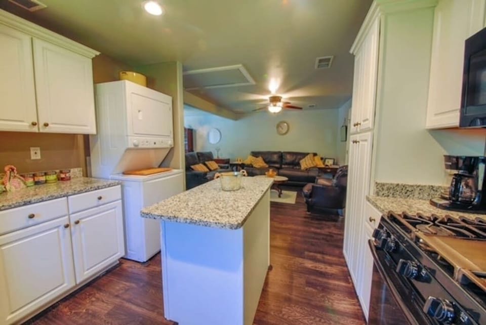 Full pantry and cabinets with kitchen center island complete this full functional kitchen with stackable washer dryer for use.