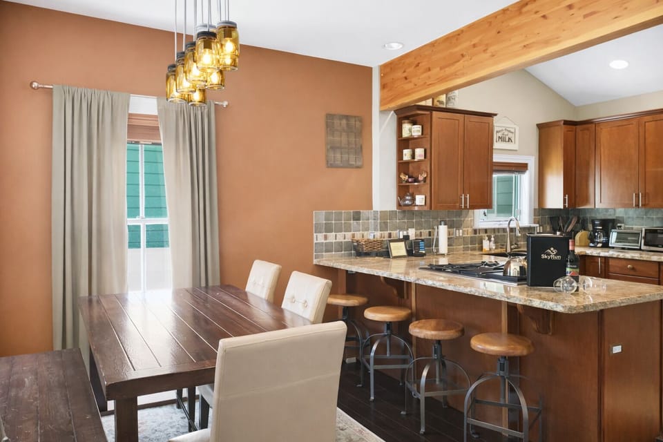 Your open-concept kitchen and dining space invites you to gather, cook, and share meals together. Warm wood tones, a granite island with bar seating, and vaulted ceilings create a welcoming heart of the home.