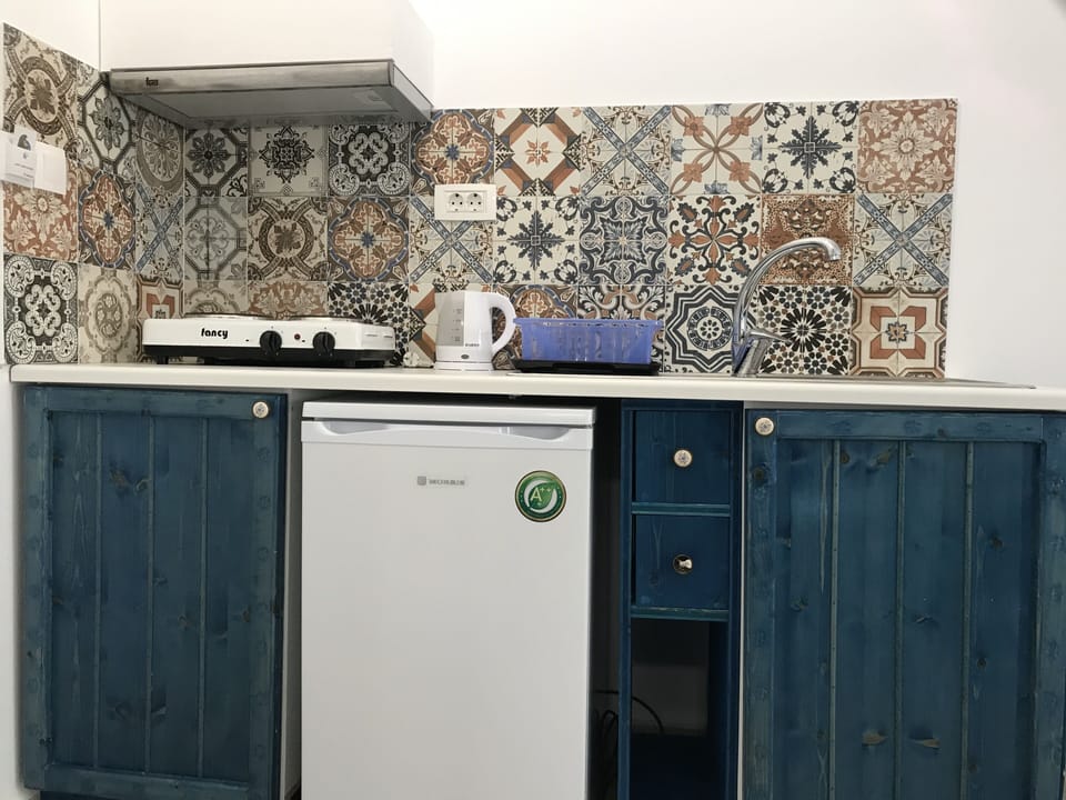 Full-size fridge, stovetop, electric kettle, cookware/dishes/utensils