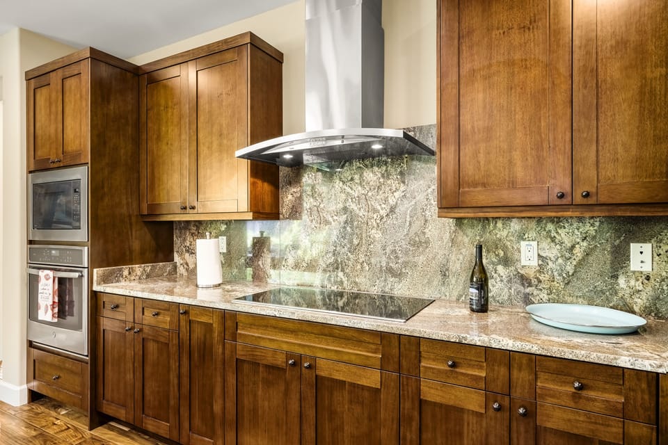 The oven range, built into the countertop, next to the microwave, and an oven built into the cabinetry.