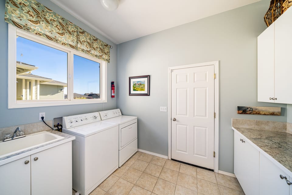 Laundry room with sink, full size washer/dryer, counter space with storage areas