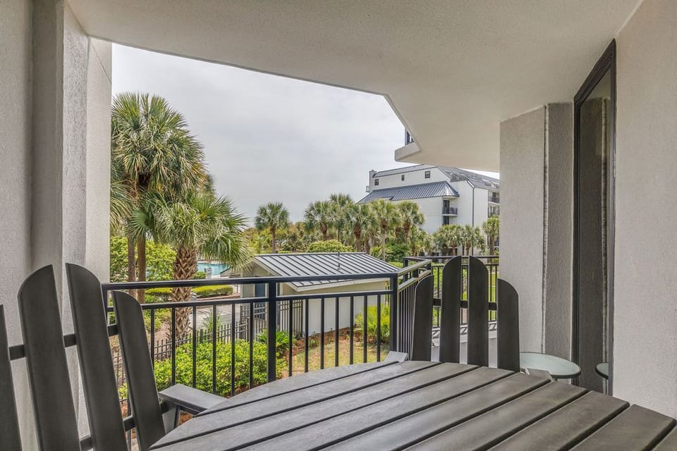 Private balcony offering beautiful ocean and pool views—conveniently located off the living room and primary bedroom.