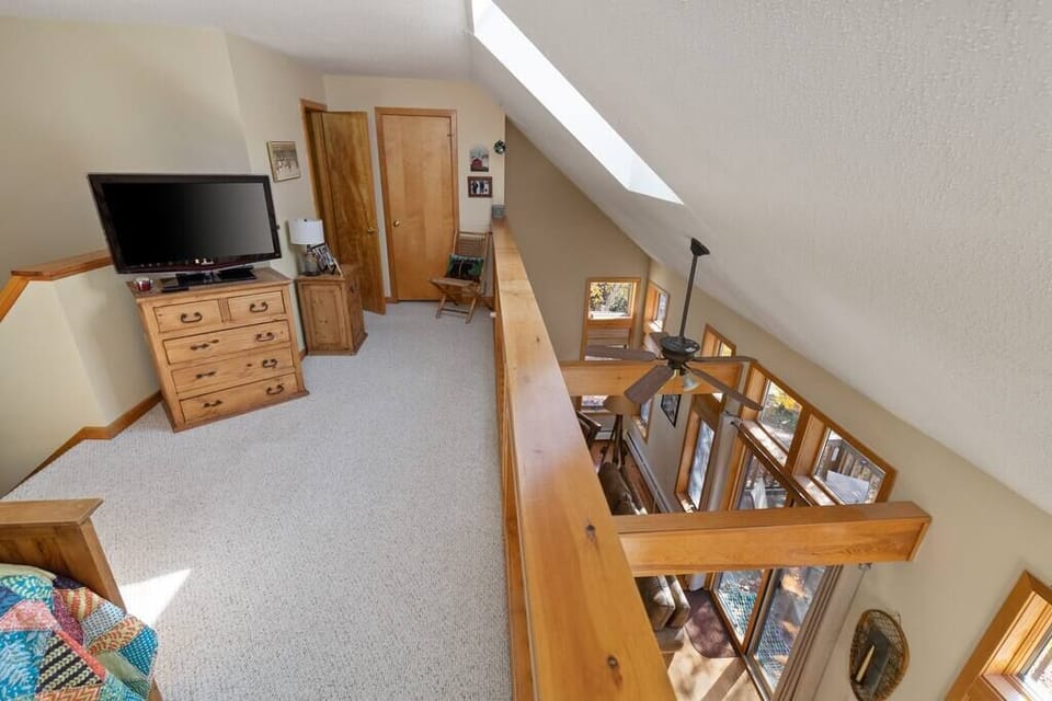Full sized bed in the loft area with smart tv.