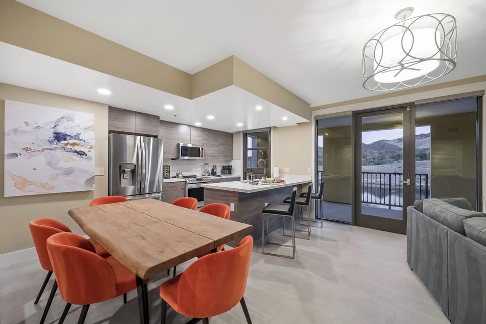Brightly lit kitchen and great-room with large dining table for six and sit up bar seats 3 more.