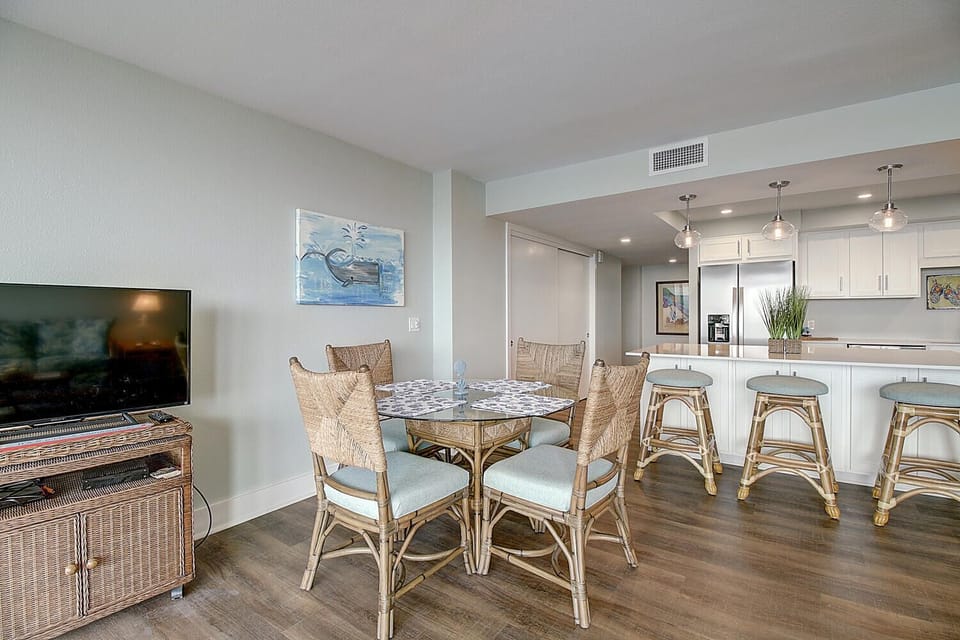 Relax in your bright, open dining area with coastal-style wicker seating and a modern kitchen perfect for preparing memorable meals together.