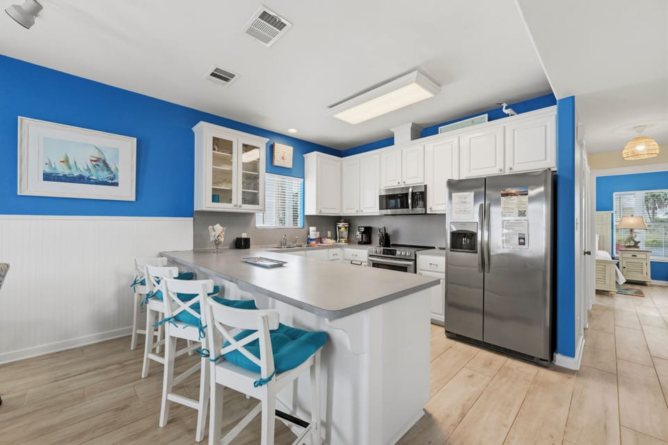 Whip up your favorite meals in this bright, fully-equipped kitchen featuring a spacious island with bar seating, stainless steel appliances, and ample storage—perfect for cooking and gathering with friends or family.