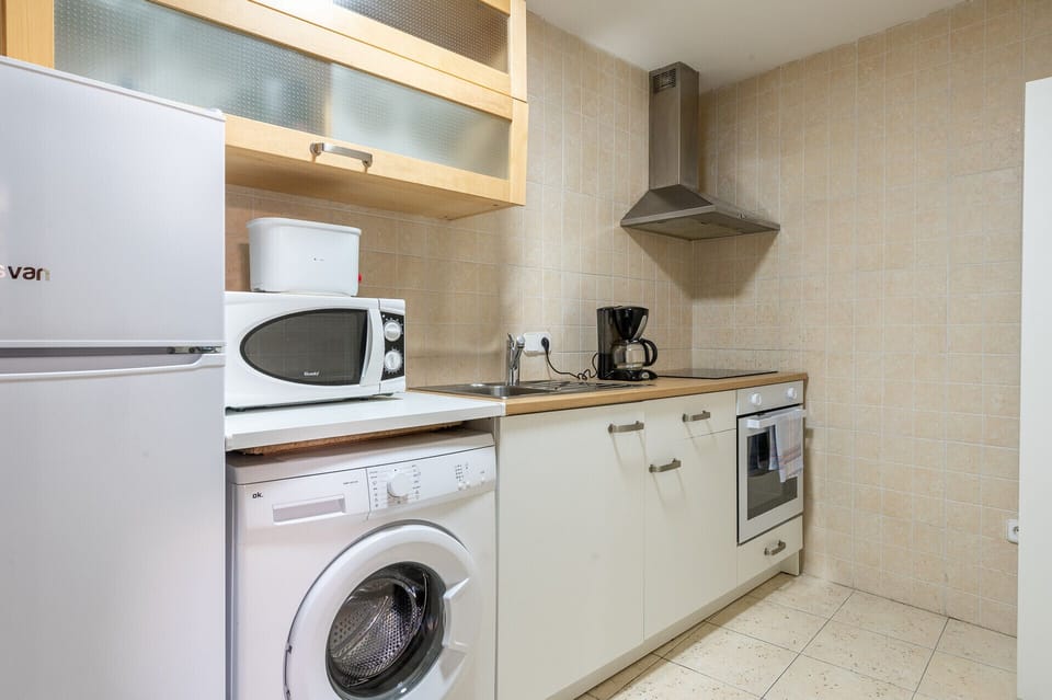 The fully equipped kitchen at Holiday Palma Apartment 3 has an oven, microwave, coffee maker, kettle, kitchen utensils and washing machine.