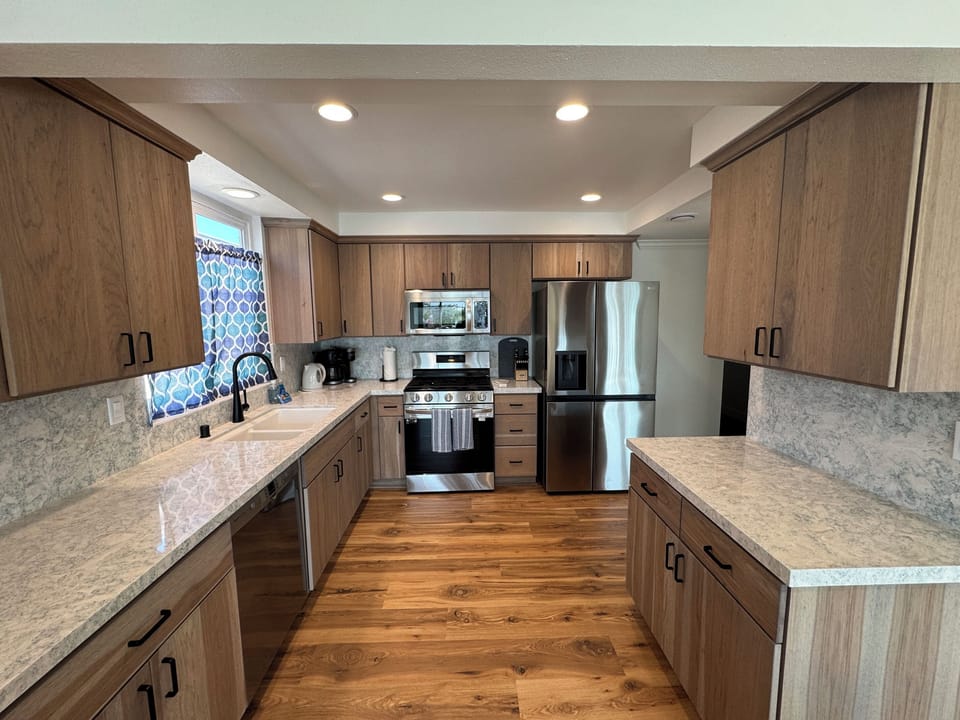 Upper Unit Kitchen – One of Two Fully Remodeled Kitchens
Fully remodeled kitchen with quartz countertops, stainless steel appliances, gas range, dishwasher, and a Keurig Duo coffee maker with both single-serve K-Cup and 12-cup drip options.