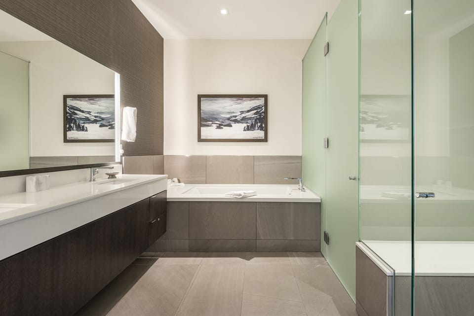 Main bathroom with tiled jetted tub, glass panel shower and frosted glass toilet enclosure