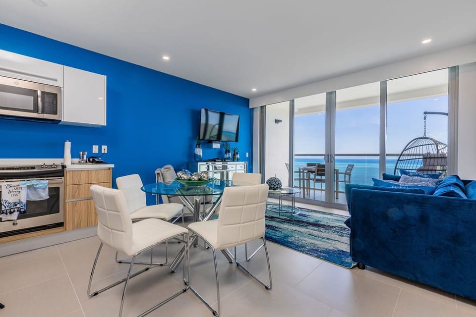 Step into your vibrant coastal retreat, where bold blue accents meet stunning ocean panoramas. Relax in the modern living space or dine while soaking in the endless sea views from your private balcony.