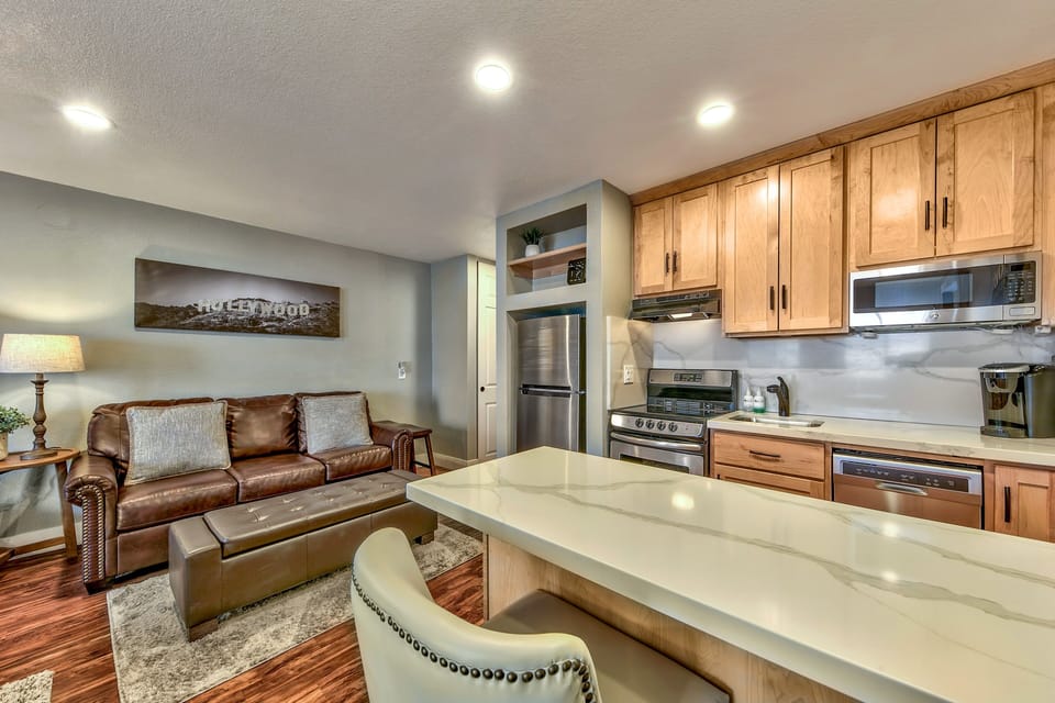 Relax in your open-plan living space with a leather sofa, fully equipped kitchen, and warm wood finishes creating the perfect home base.