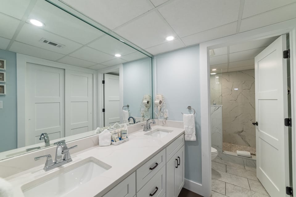 The main suite bathroom has a separate dressing area with double vanities and a separate tiled walk in shower and toilet area for privacy.