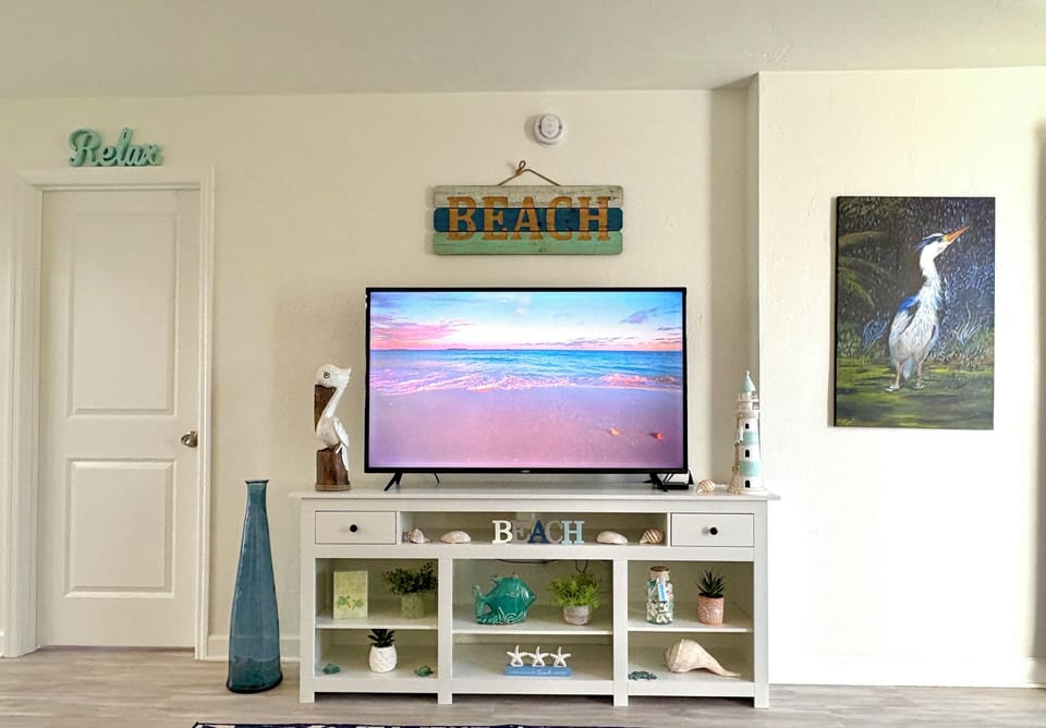 Living room with large flat-screen TV on stand and sofa