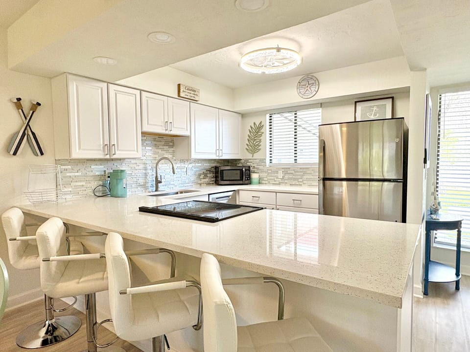 Kitchen with white cabinetry and stainless steel refrigerator