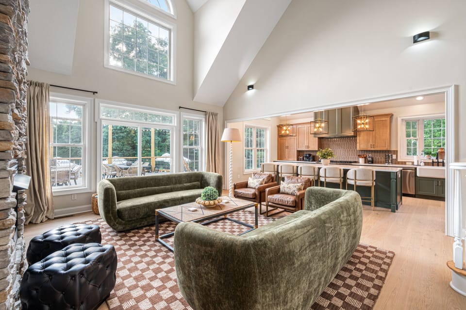 [Main Living Area] Expansive windows offer seamless access to the outdoor deck and scenic backyard views.