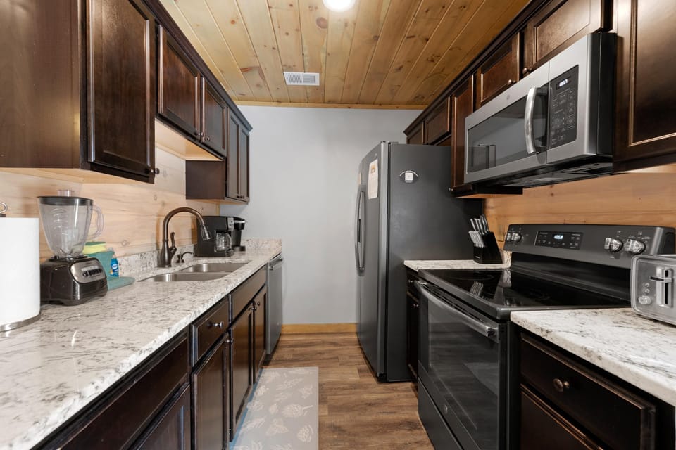 The kitchen is fully stocked with dishes, pots, pans, and stainless steel appliances. Both a drip coffee maker and Keurig are at your service!