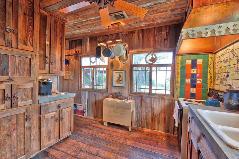 The kitchen features a range with oven and plenty of cooking pots.