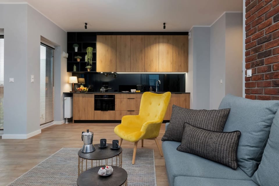 The living area with a grey sofa is the place to relax and the modern kitchenette invites you to prepare home-cooked meals.