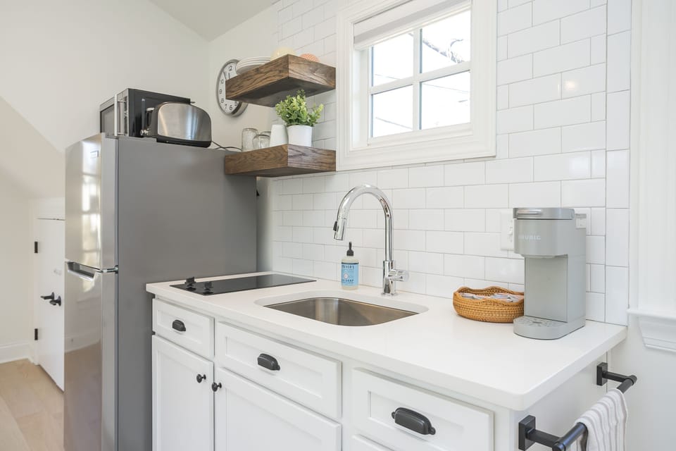 Kitchen includes a stovetop, microwave, toaster, and coffee maker