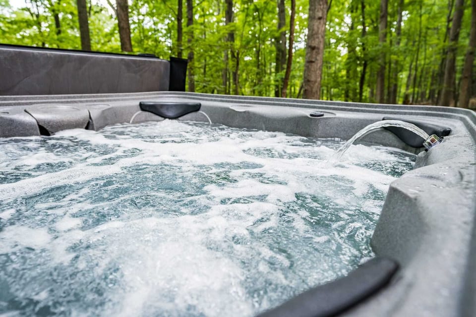 Relax in the bubbling hot tub surrounded by peaceful forest views.