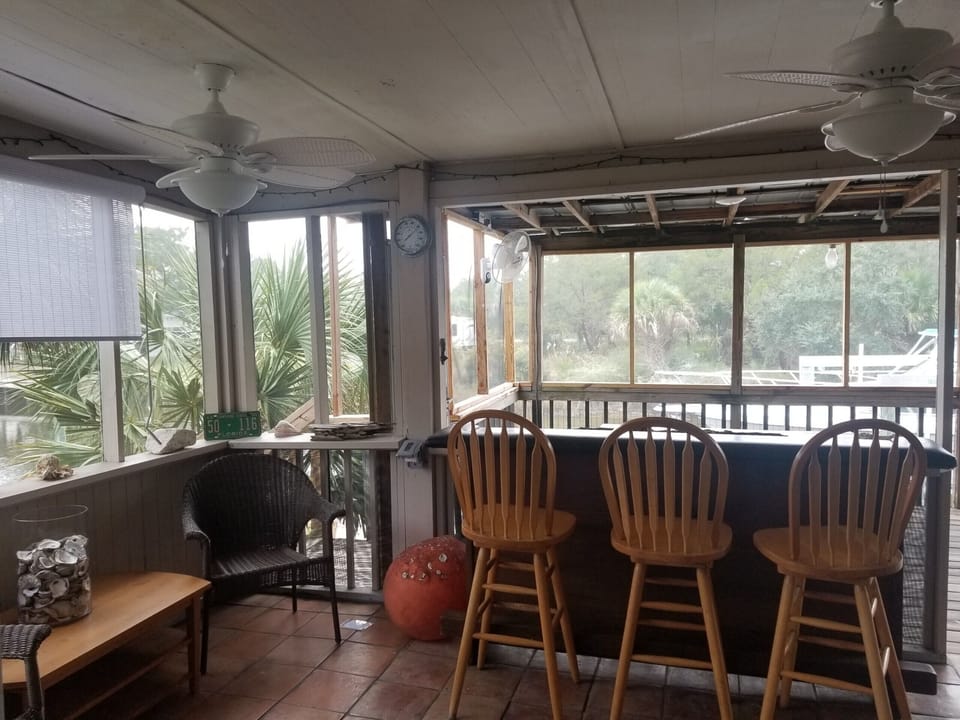 large screen porch has water views of the canal and its own bar with barstools