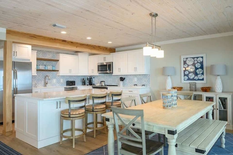 - Open dining space & kitchen make it easy to serve, sit down, & enjoy time together - Table with bench seating fits everyone comfortably for meals or gatherings - Soft tones, coastal artwork, & cozy lighting make the room feel warm & welcoming