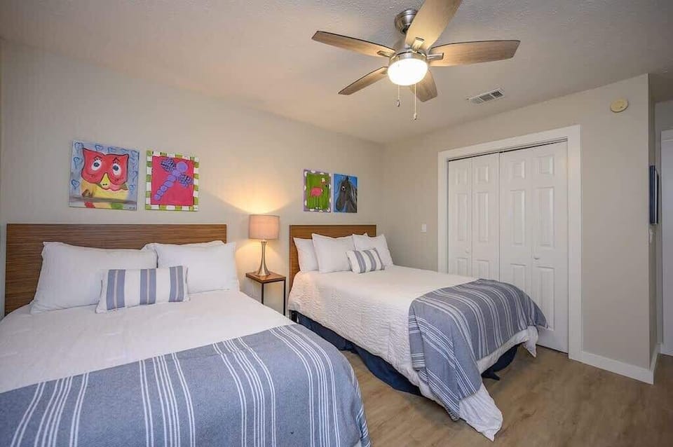- Two full size beds with matching striped bedding provide comfort and space for a restful sleep - Soft lighting and ceiling fan keep the atmosphere cool and cozy all day - Playful wall art and natural floor add a cheerful beachy touch