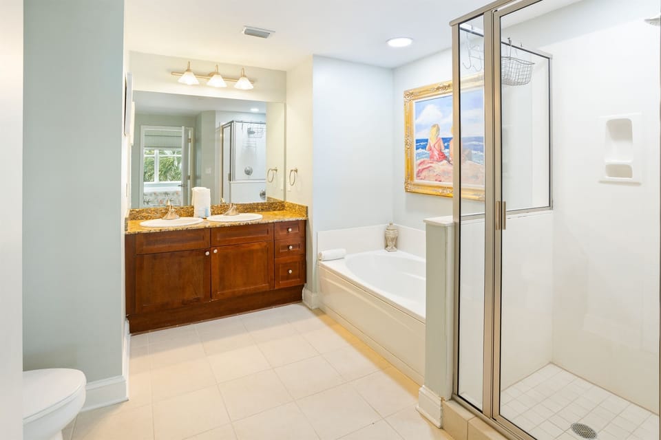 Step into your spa-like bathroom sanctuary with elegant granite vanity, soaking tub, and spacious glass shower.