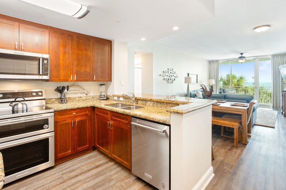 Your fully equipped kitchen features granite countertops, stainless appliances, and opens to your bright living space with stunning ocean views.