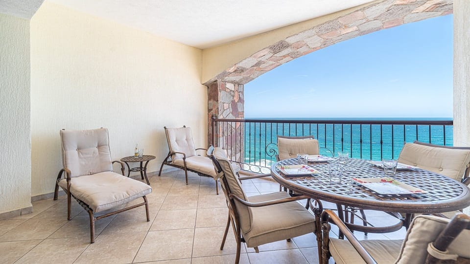 On the balcony are a dining table and chaise chairs