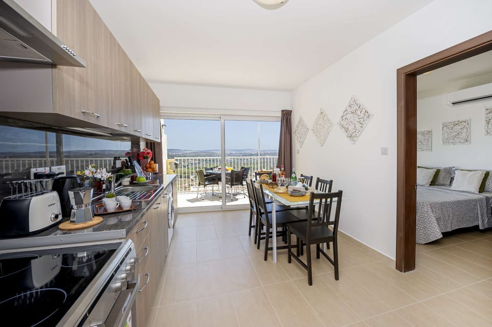 fully equipped kitchen and dining area overlooking the sunny terrace with views