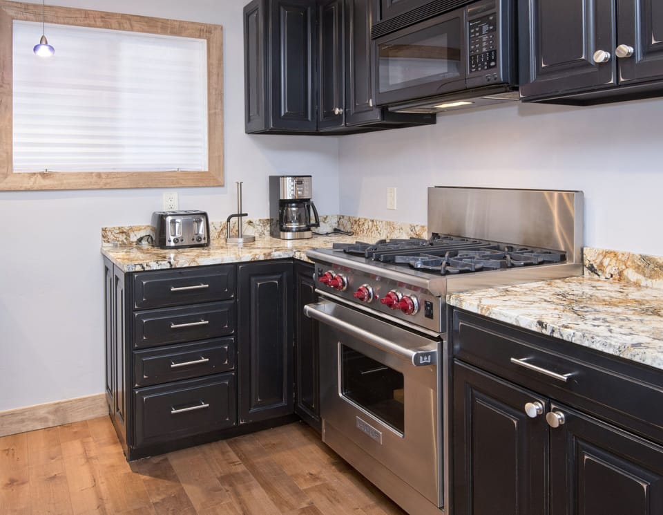 Nice granite countertops with a high end stove.