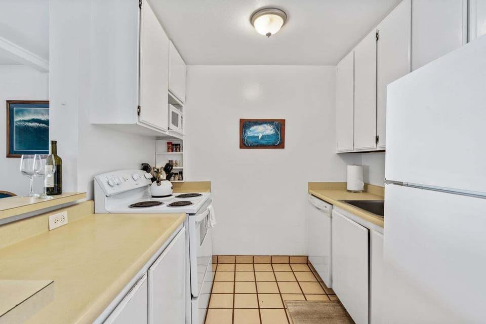 Tastefully updated kitchen with modern appliances, cookware, and a fresh island-inspired design — perfect for preparing quick meals or full dinners.