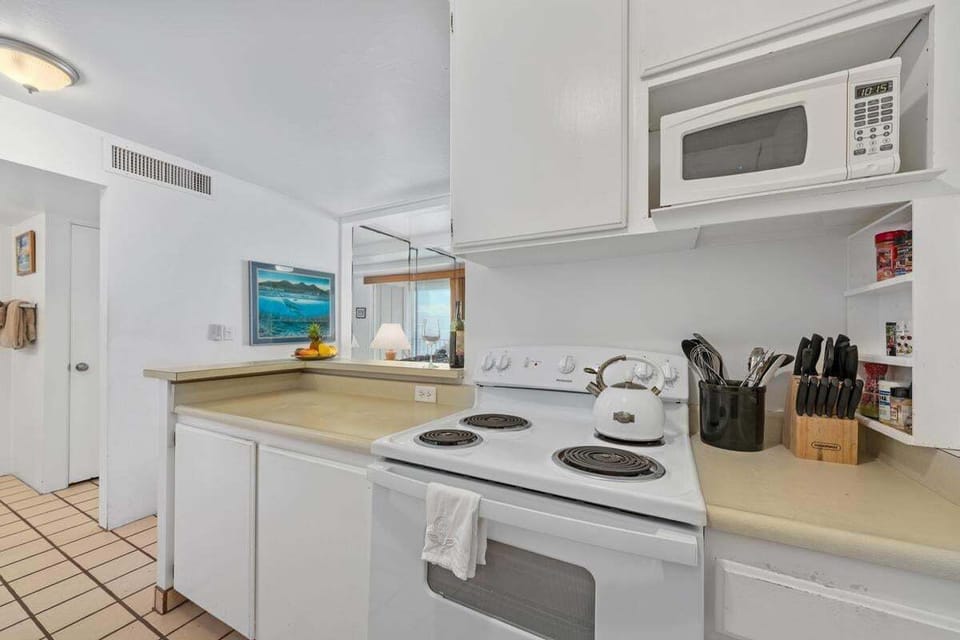 Tastefully updated kitchen with modern appliances, cookware, and a fresh island-inspired design — perfect for preparing quick meals or full dinners.