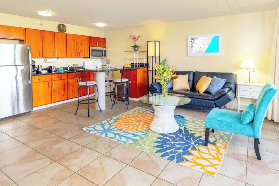 Living room with open kitchen, reclining sleeper sofa, and window AC