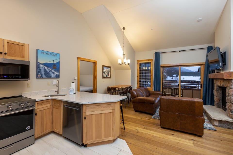 Your modern mountain retreat features a full kitchen, cozy fireplace, and stunning mountain views from your private balcony.