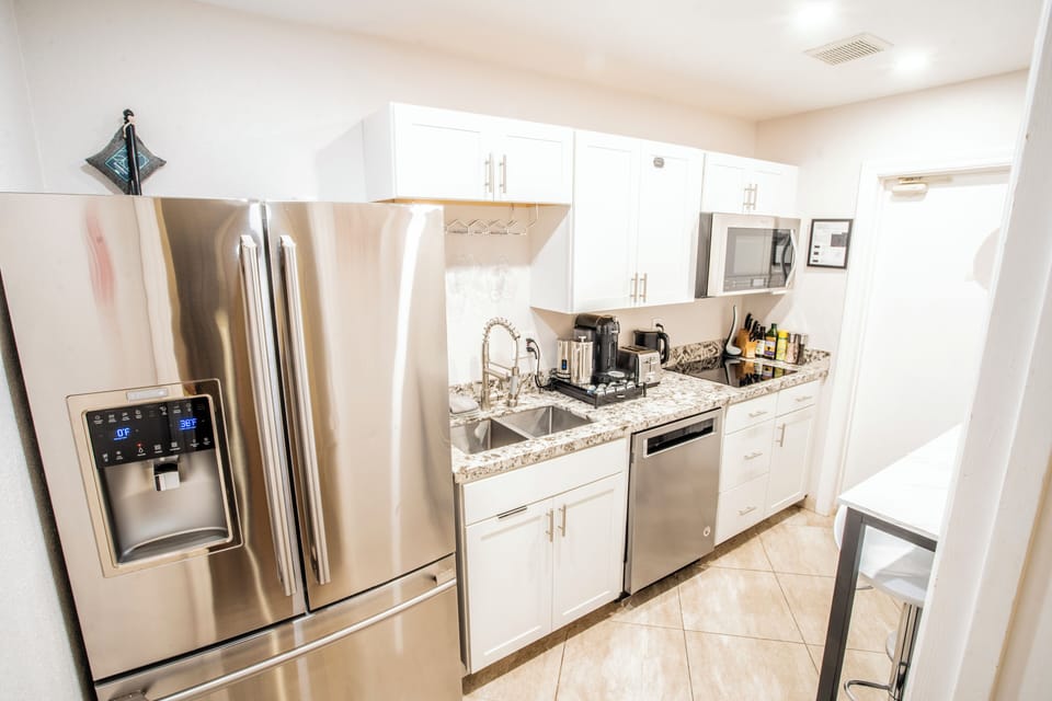 Full kitchenette with stovetop, range hood microwave, full sized fridge/freezer