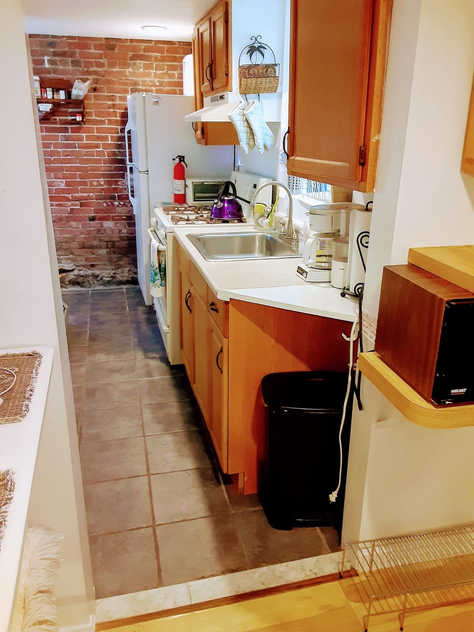 Galley kitchen is fully equipped with full-size appliances, dishes, pots & pans.