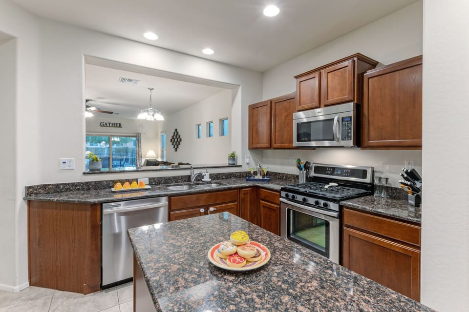 Modern kitchen has stainless steel appliances and is well stocked with culinary tools.