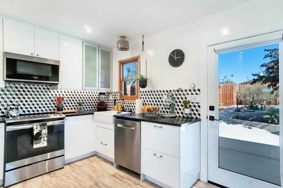 Spacious open kitchen with modern stainless steel appliances, high gloss cabinets and modern backsplash has everything you need to whip up an amazing farm-to-table meal - cookbook included!