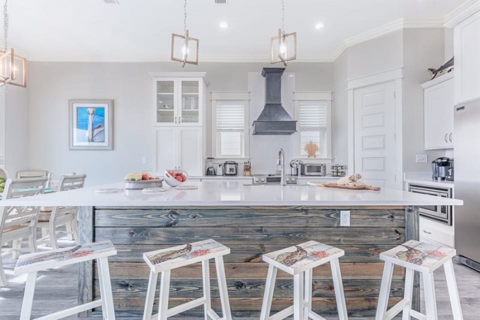 Your gourmet kitchen awaits with marble countertops, premium appliances, and coastal charm - perfect for preparing memorable meals together.