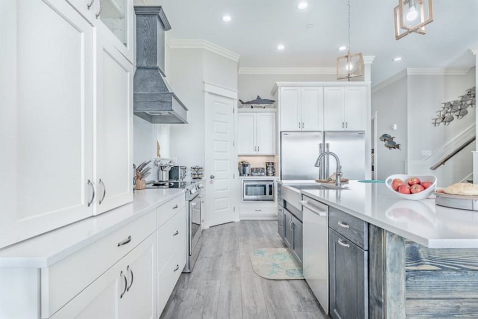 You'll love cooking in this stunning coastal kitchen with gleaming counters, modern appliances, and charming nautical touches throughout.