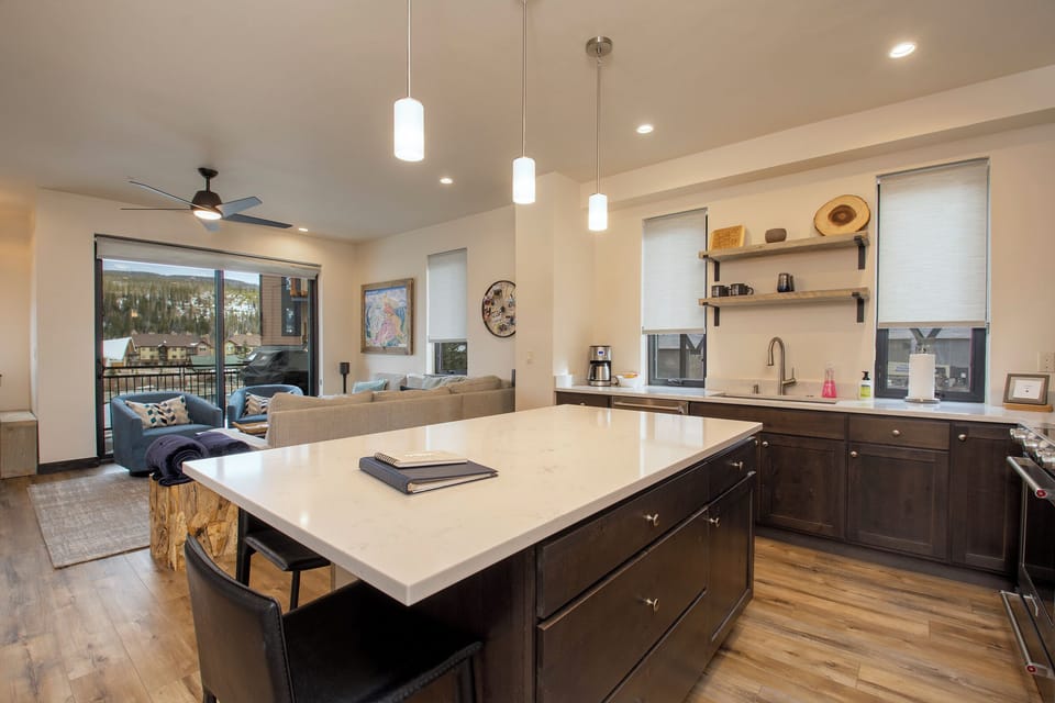 Your spacious kitchen island becomes the heart of gatherings, with sleek countertops and mountain views creating the perfect backdrop for memorable meals.