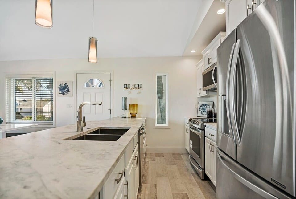 Kitchen with all new stainless steel appliances and cookware.
