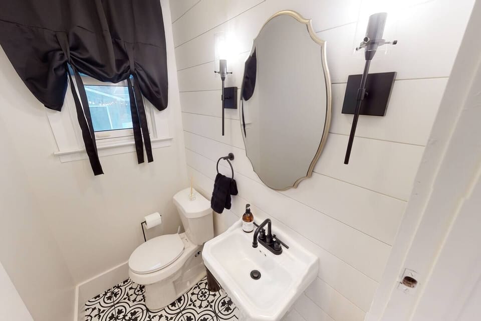 Main Level Half Bathroom with beautifully tiled floors and ship lap back splash.  