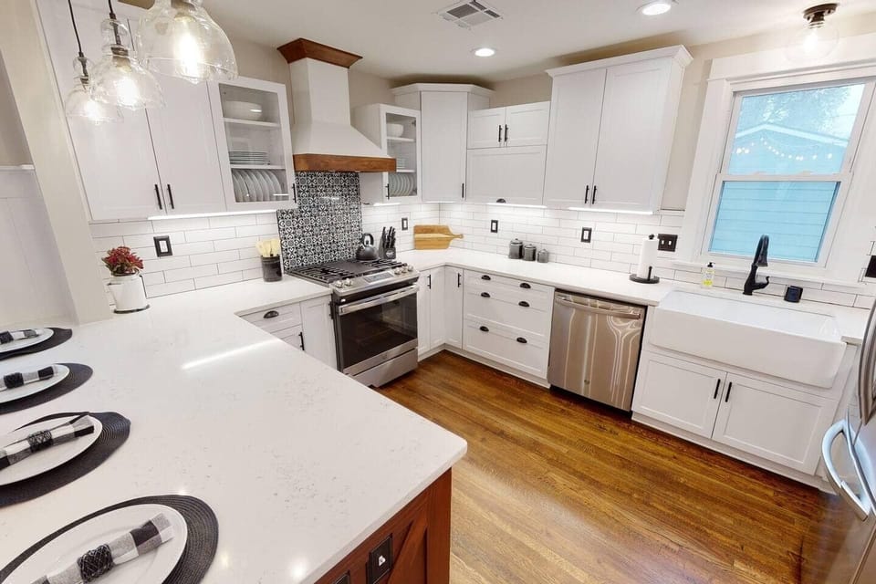 Fully stocked kitchen with tiled backsplash and under cabinet lighting. 