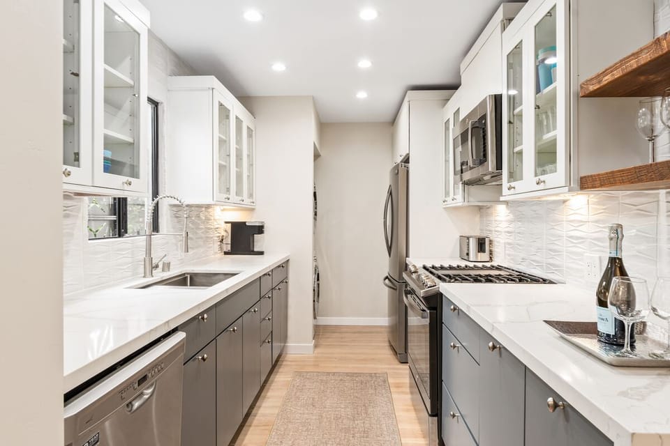 Newly remodeled kitchen with stainless appliances and full-sized washer/dryer.