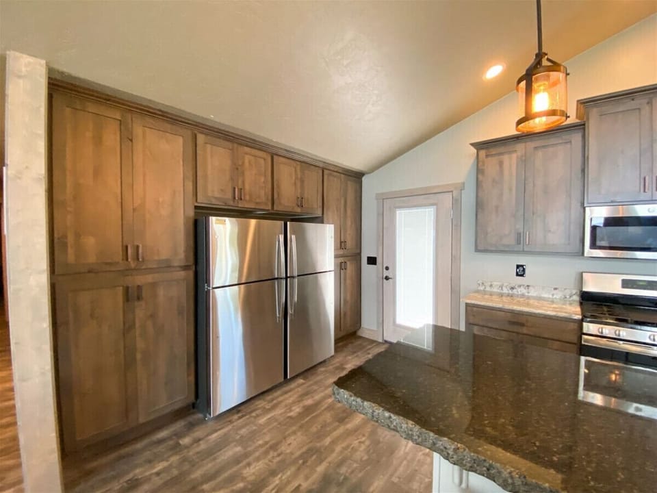 Double stainless-steel fridge and rich wood cabinetry offer style and space for effortless entertaining.
