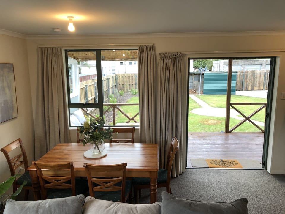 Dining area with double doors that lead to the deck, bbq and outdoor loung suit.